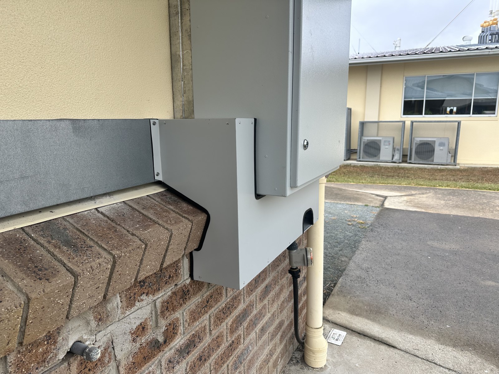 Sheet metal flashing fitted around wall-mounted equipment by Ocean Air Mackay